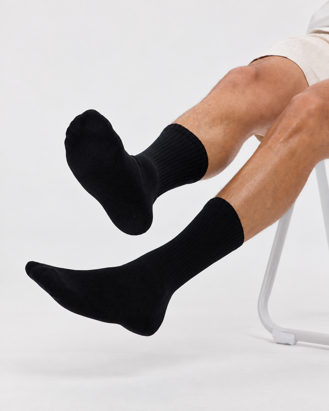 Black Base Supply ribbed crew socks worn by a seated model