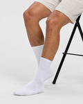 Base Supply white ribbed crew socks worn by a seated model