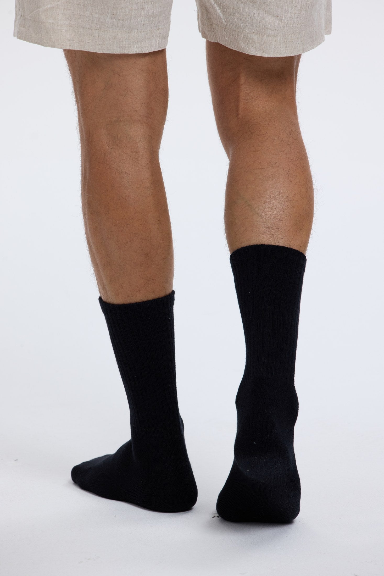 Close portrait of black Base Supply crew socks being worn